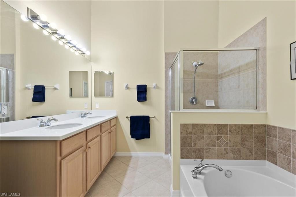 2806 Orange Grove Trail Naples, FL 34120 - Photo 10 of 24 a spacious bathroom with a tub sink shower and mirror