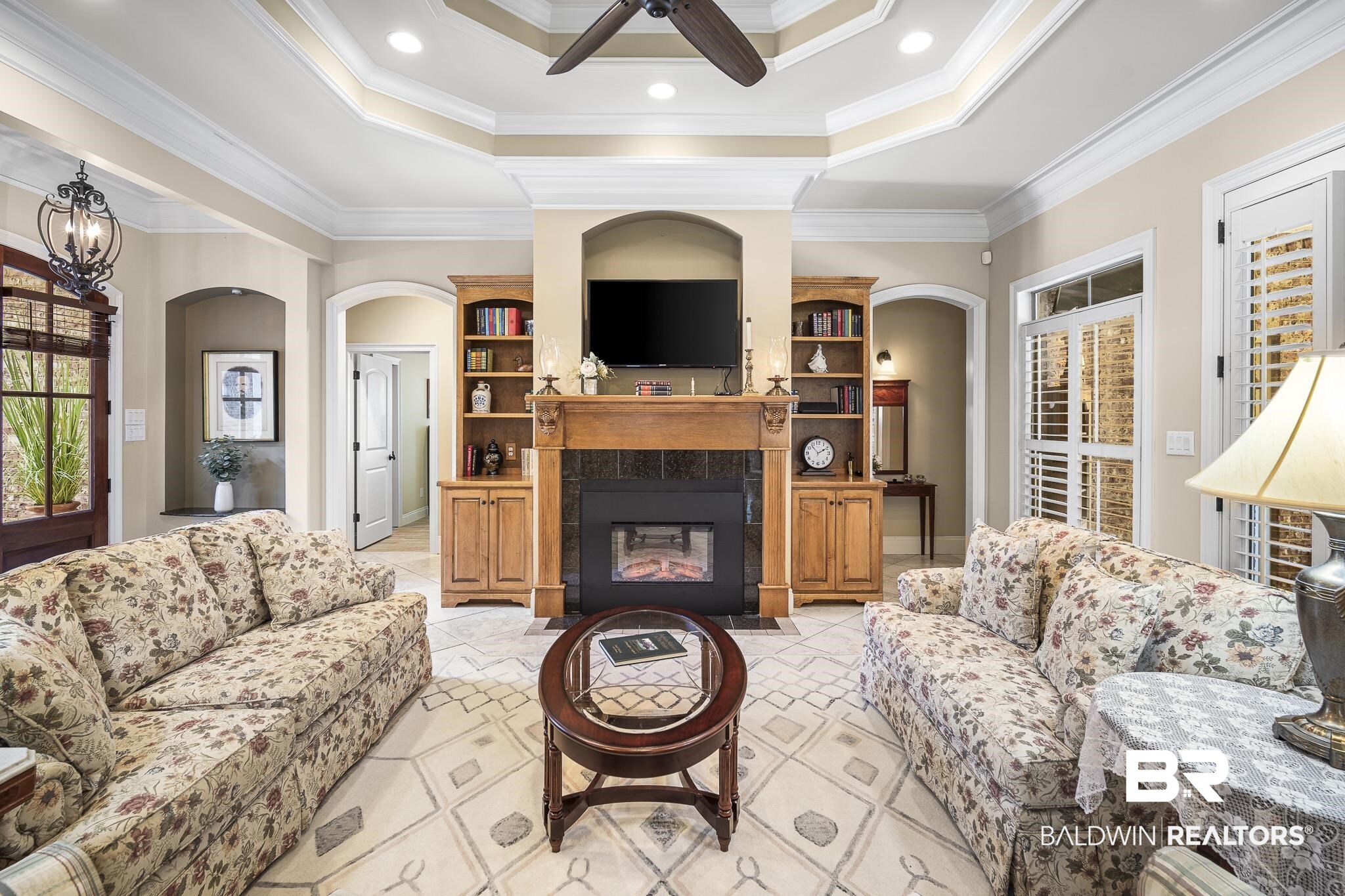 7090 Carson Lane Daphne, AL 36527 - Photo 4 of 37 Tiled living room with a tray ceiling, ceiling fan, crown molding, and a tile fireplace