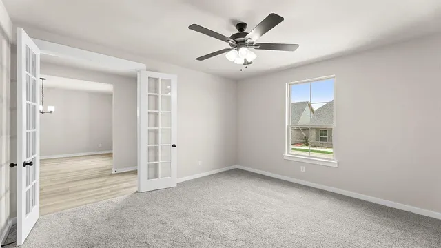 an empty room with windows and fan