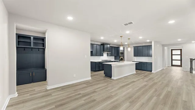 a kitchen with stainless steel appliances kitchen island granite countertop a refrigerator and a sink