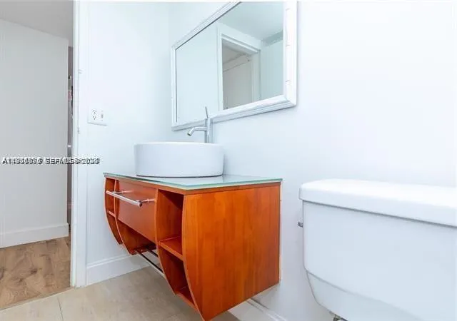 a bathroom with a sink a toilet and mirror