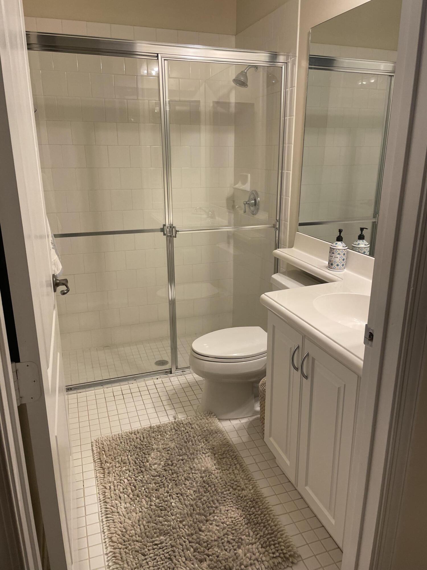 558 North West 39th Circle Boca Raton, FL 33431 - Photo 3 of 25 a bathroom with a sink a toilet a mirror and shower