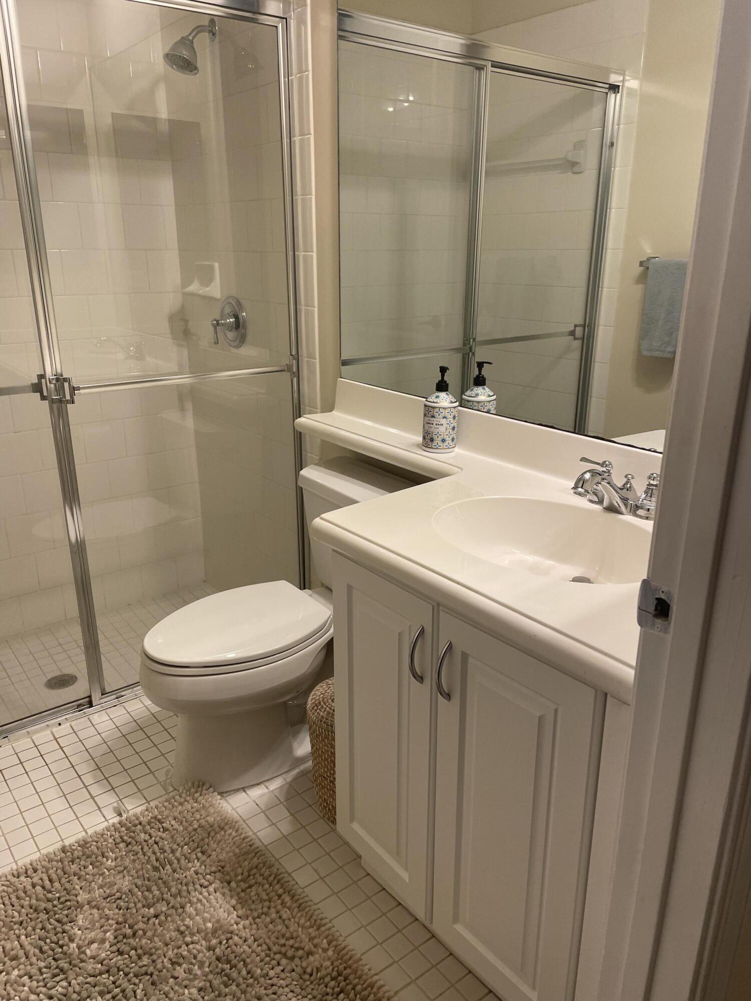 558 North West 39th Circle Boca Raton, FL 33431 - Photo 4 of 25 a bathroom with a sink a toilet a mirror and shower