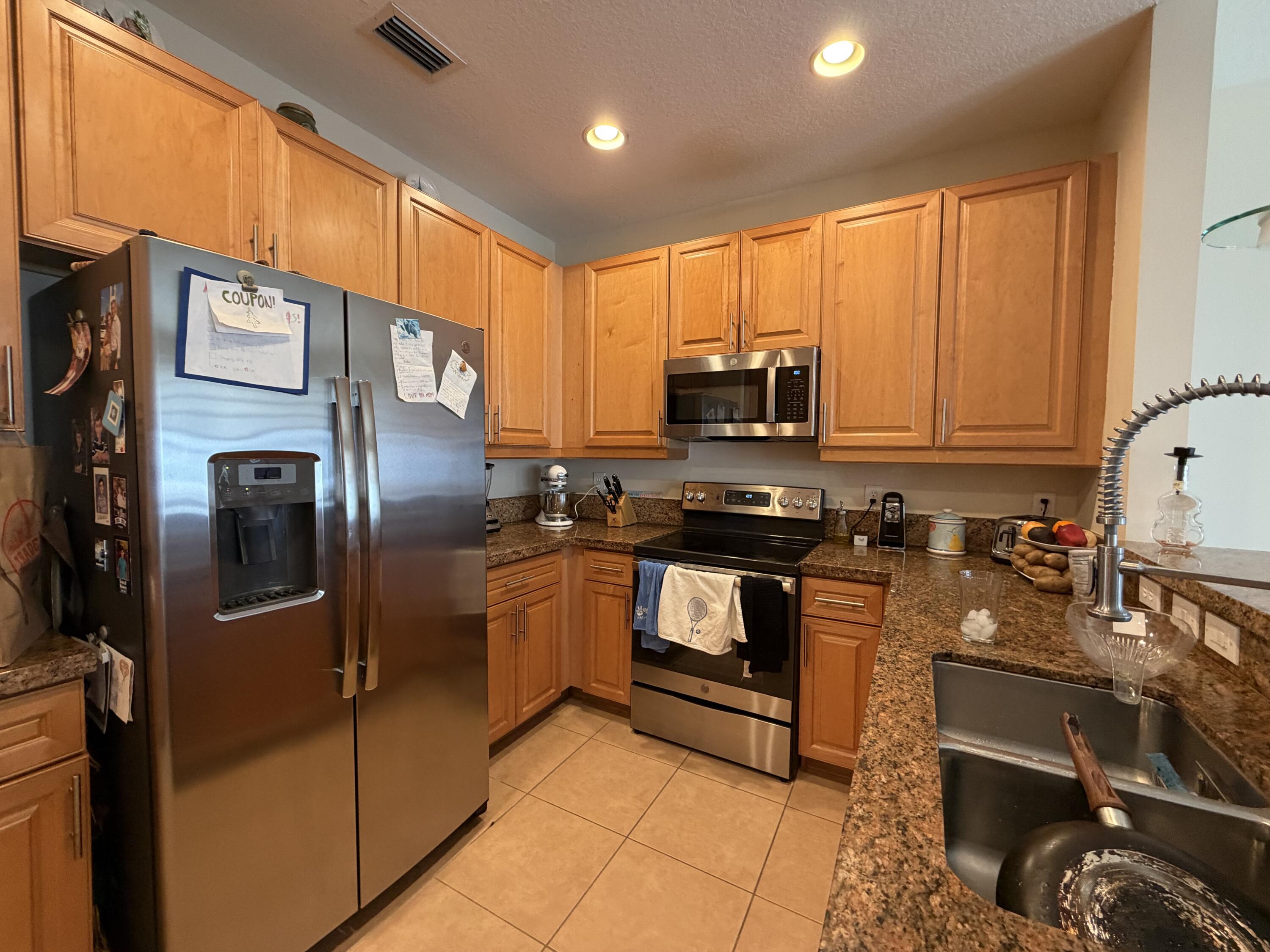 558 North West 39th Circle Boca Raton, FL 33431 - Photo 9 of 25 a kitchen with stainless steel appliances a refrigerator a stove a sink and a microwave
