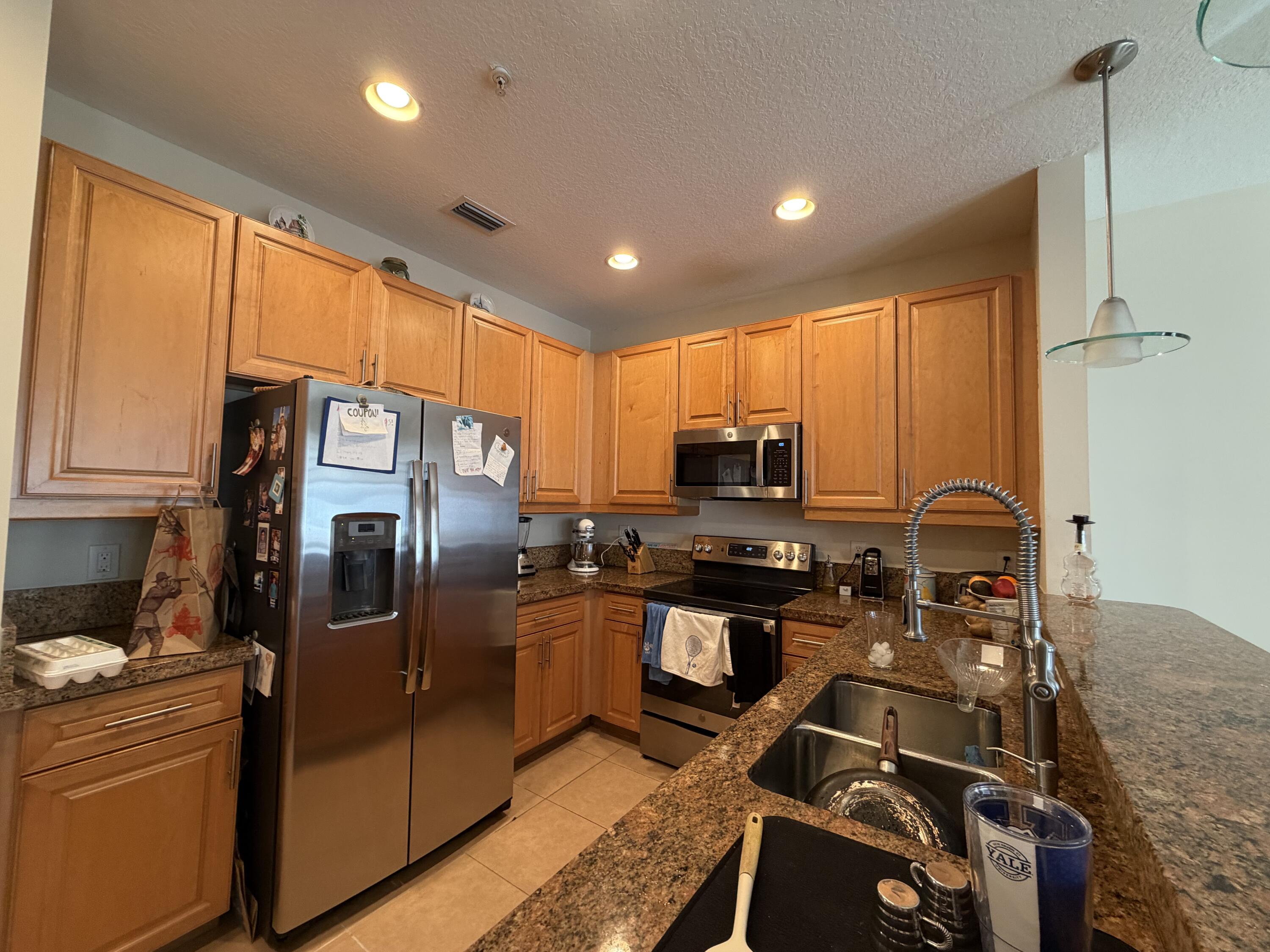 558 North West 39th Circle Boca Raton, FL 33431 - Photo 10 of 25 a kitchen with stainless steel appliances granite countertop a refrigerator stove and sink