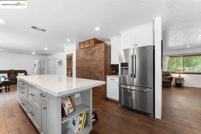 a kitchen with stainless steel appliances a refrigerator sink and wooden floor