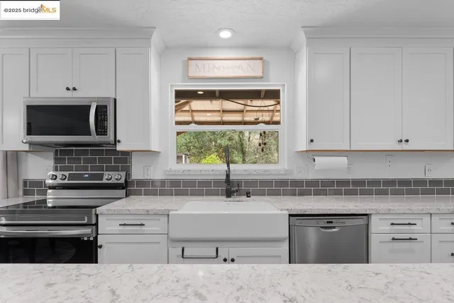 a kitchen with stainless steel appliances kitchen island granite countertop a sink stove and microwave