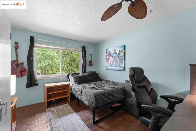 a bedroom with a bed wooden floor and window