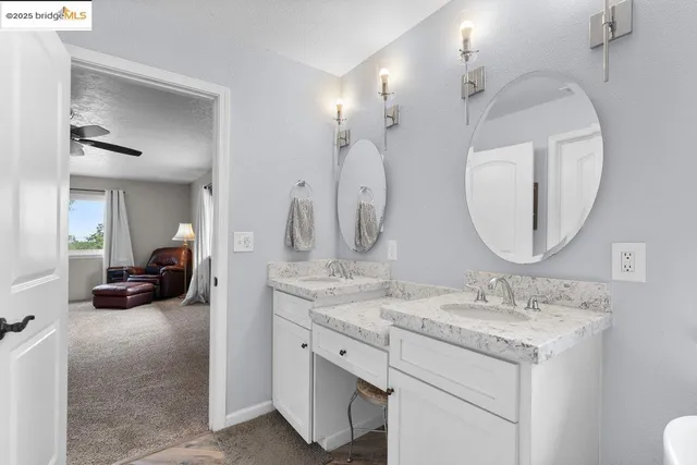 a en suite bathroom with a double vanity sink and a mirror