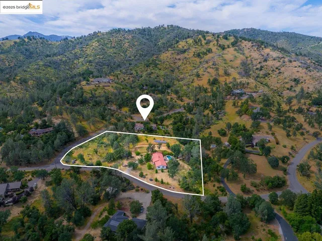 an aerial view of a house with a yard and lake view