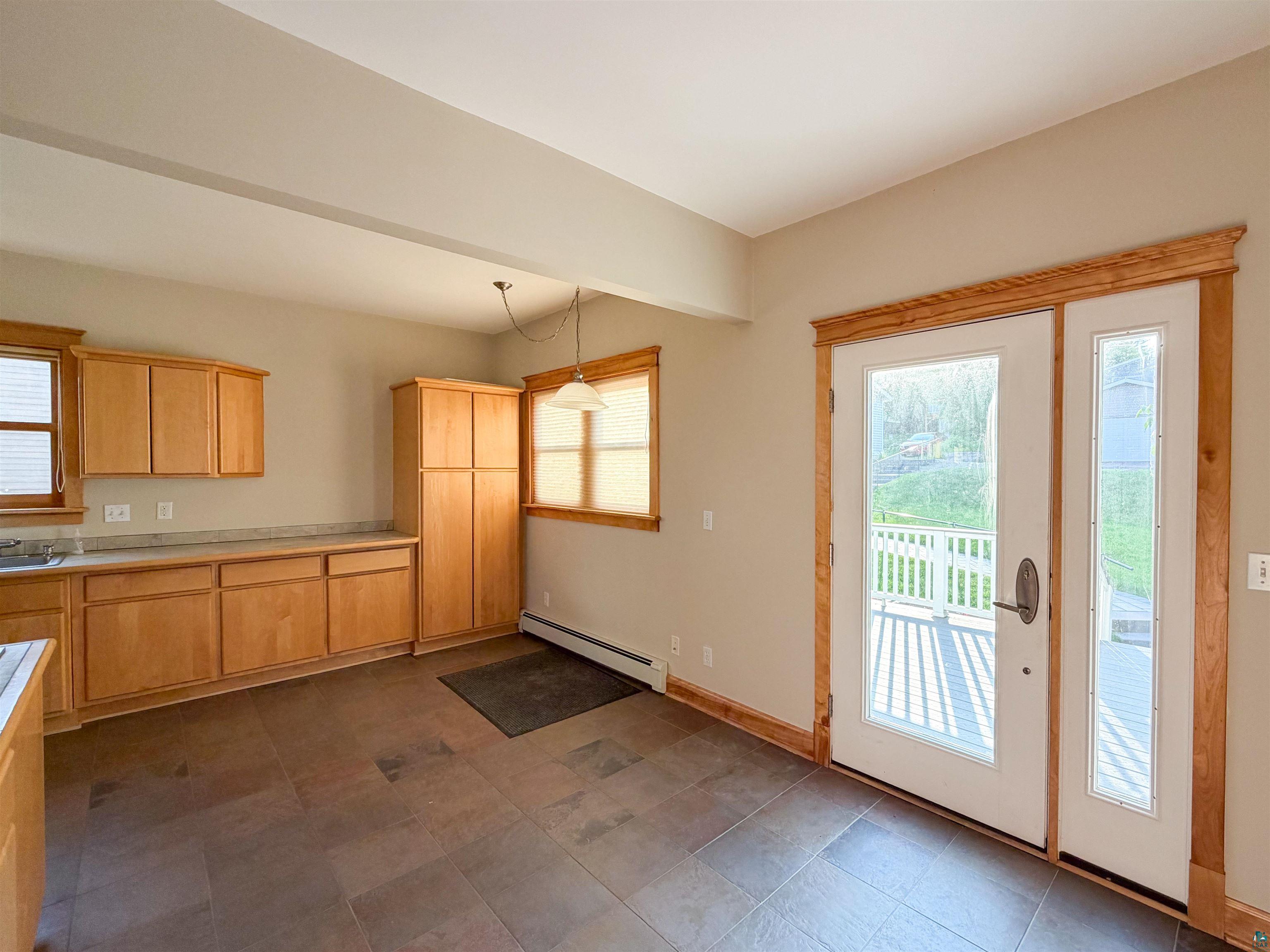 13 West 8th Street Duluth, MN 55806 - Photo 14 of 57 Spacious kitchen area featuring warm wood cabinetry, a built-in pantry, and a large tile floor