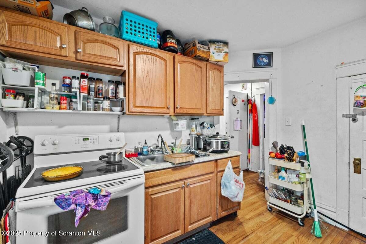 120 Ridgeway Street East Stroudsburg, PA 18301 - Photo 31 of 49 a kitchen with stainless steel appliances granite countertop a sink dishwasher and cabinets with wooden floor