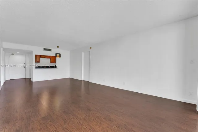 a view of a room with wooden floor and windows