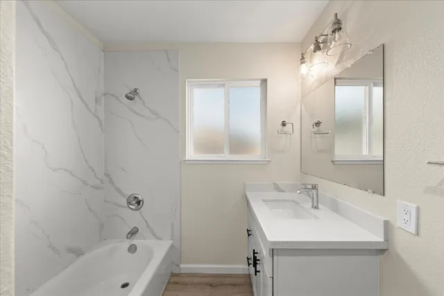 a bathroom with a sink a mirror and a bathtub