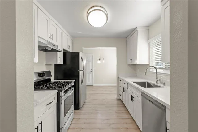 a kitchen with stainless steel appliances a sink stove and refrigerator