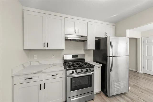 a kitchen with refrigerator a microwave and cabinets