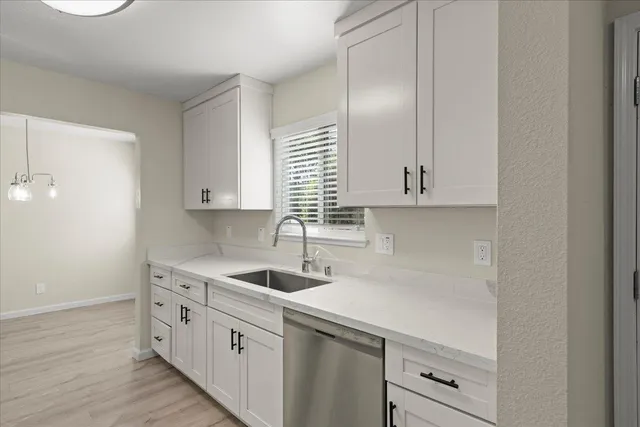a kitchen with white cabinets and white appliances