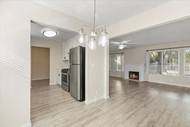 a view of a kitchen with a refrigerator a ceiling fan and wooden floor