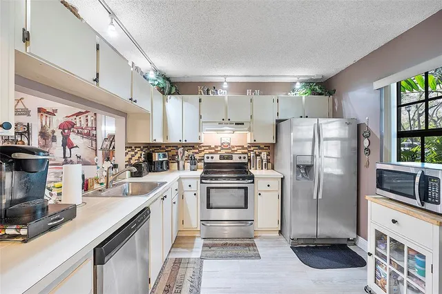 a kitchen with stainless steel appliances a refrigerator sink and cabinets