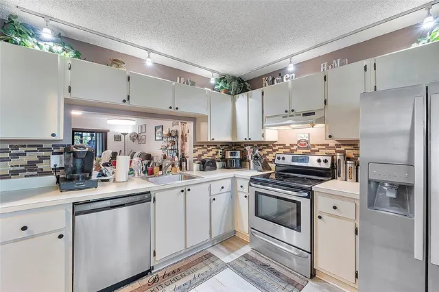 a kitchen with white cabinets and white appliances