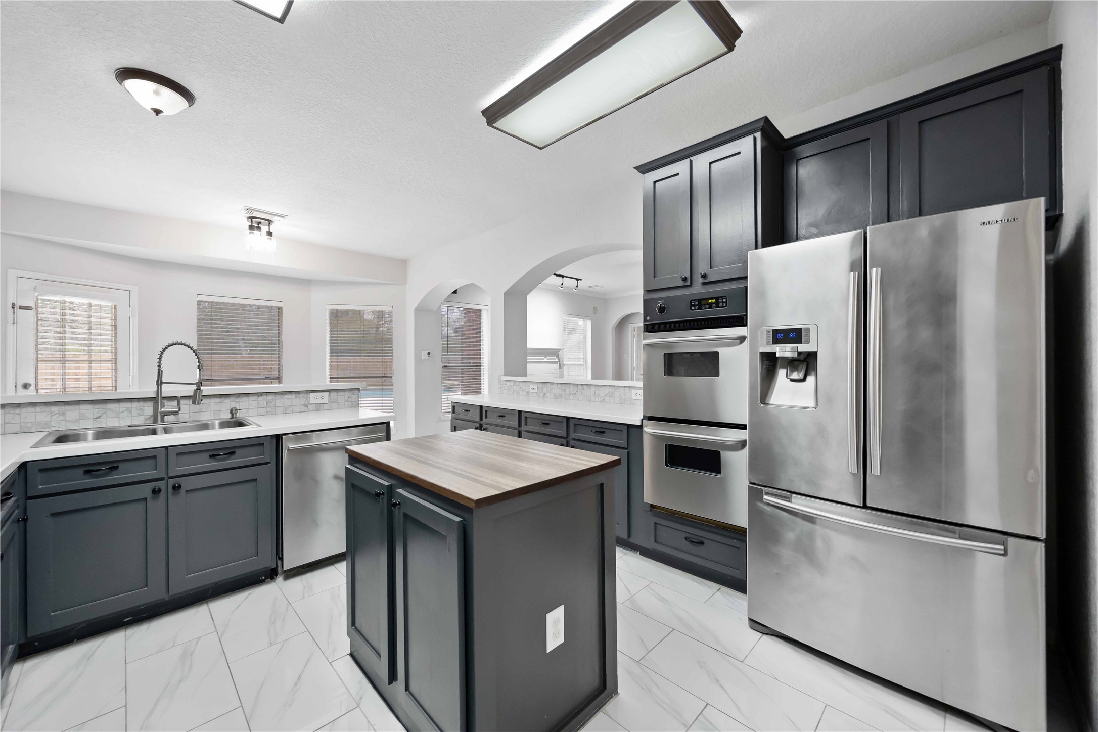 a kitchen with stainless steel appliances a refrigerator sink and stove