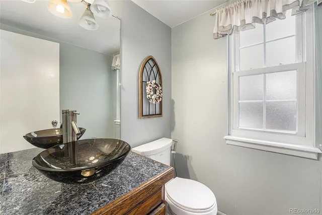 a bathroom with a toilet a sink and a mirror