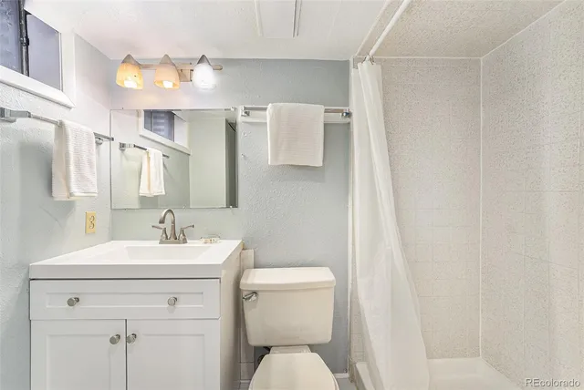 a bathroom with a sink a toilet and mirror