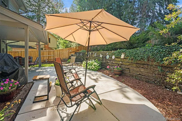 a view of patio with chairs and table under an umbrella