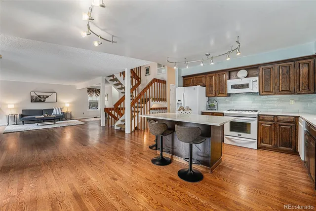 a kitchen with stainless steel appliances granite countertop a stove a refrigerator and a fireplace