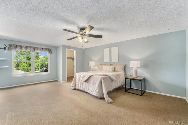 a spacious bedroom with a bed and a chandelier