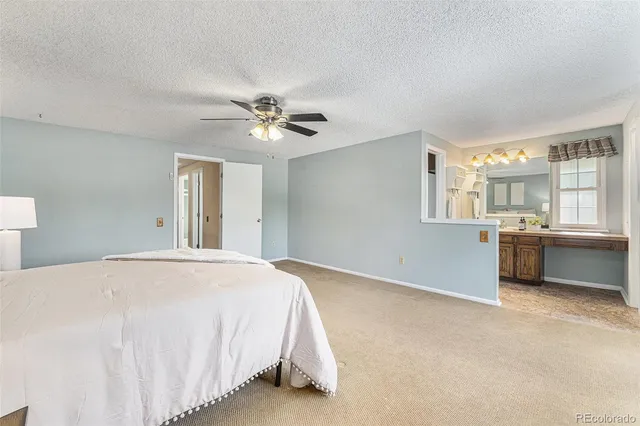 a spacious bedroom with a bed and a chandelier
