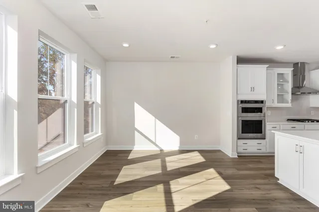 a view of kitchen with stainless steel appliances kitchen island wooden cabinets and window