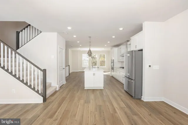 a view of a kitchen with white cabinets and wooden floor