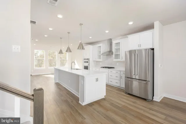 a kitchen with stainless steel appliances a refrigerator and a stove top oven