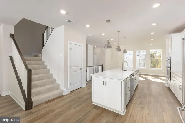 a view of a kitchen with wooden floor and electronic appliances