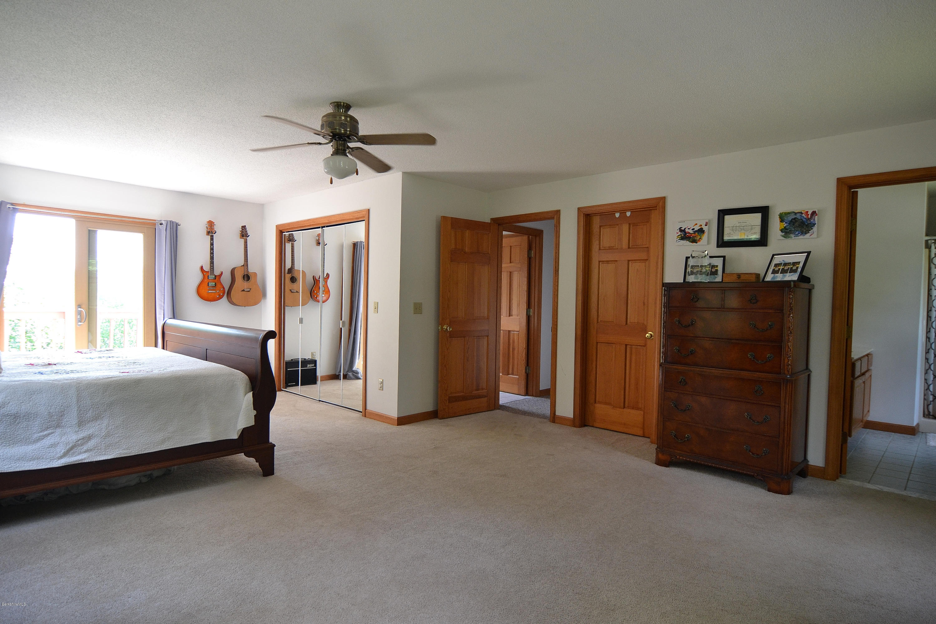 693 George Carter Road Becket, MA 01223 - Photo 27 of 36 a bedroom with a bed and a chandelier