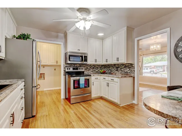 a kitchen with granite countertop a stove a sink and a refrigerator