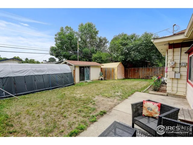 a view of a backyard with table and chairs with wooden fence