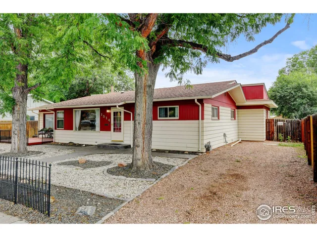 a front view of a house with a tree