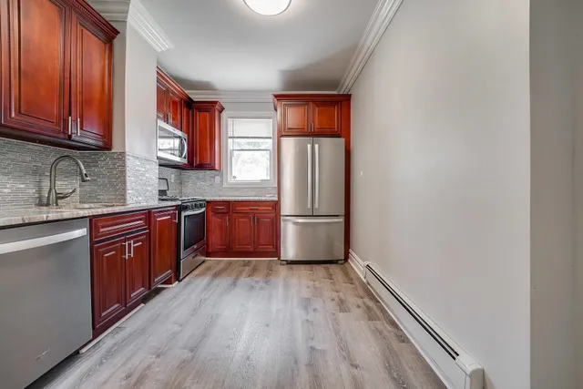 a kitchen with wooden floors and wooden cabinets