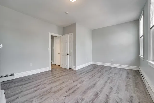 a view of an empty room with wooden floor