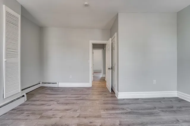 a view of an empty room with wooden floor