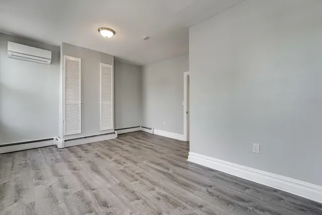 a view of an empty room with wooden floor