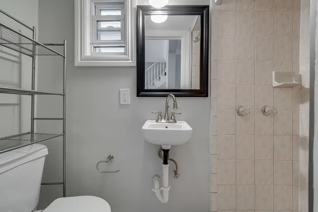 a bathroom with a sink a toilet and mirror