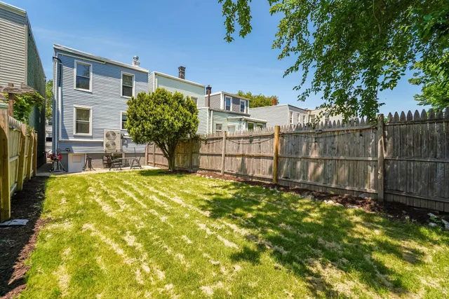 a view of a backyard with plants and wooden fence