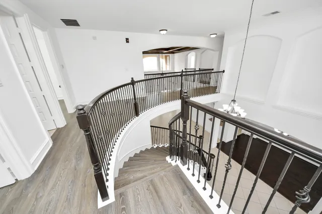 a view of staircase with railing and white walls