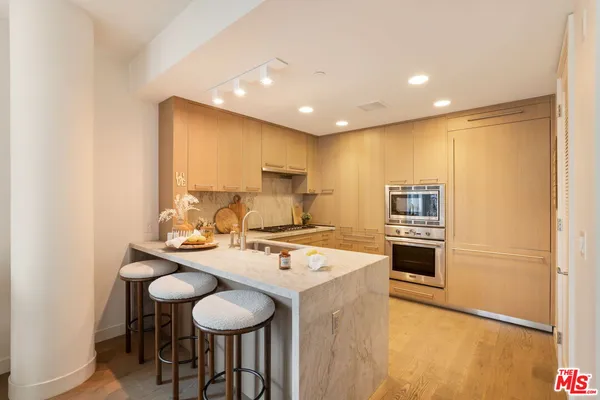a kitchen with stainless steel appliances granite countertop a sink a stove a refrigerator a microwave with a dining table and chairs