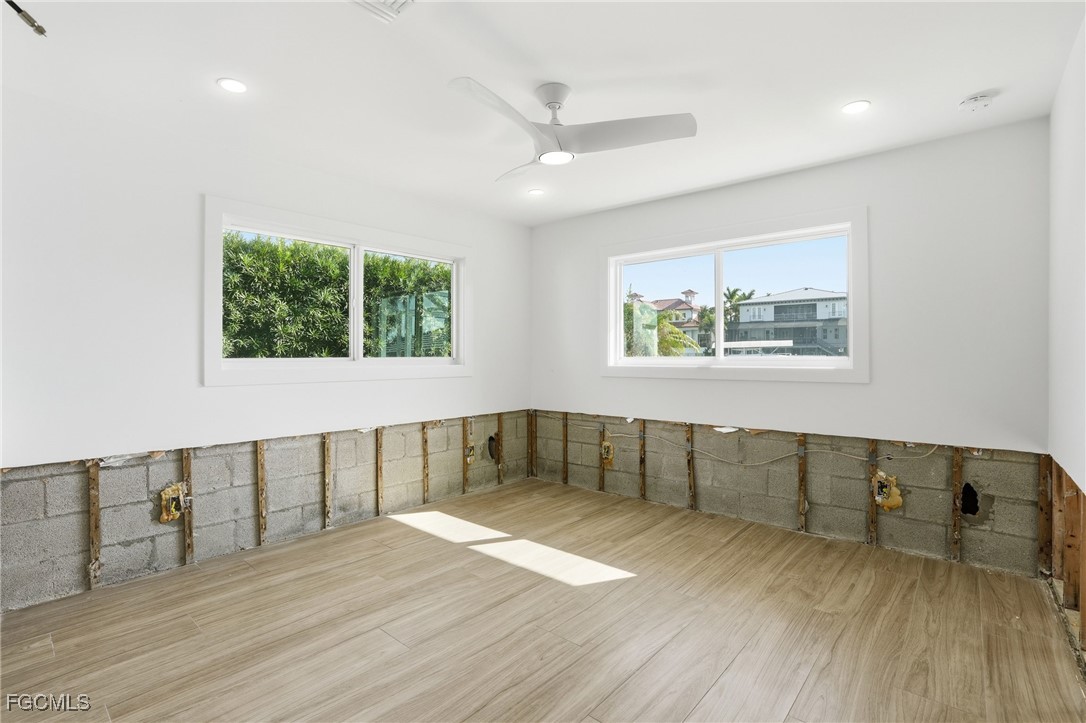 380 Conners Avenue Naples, FL 34108 - Photo 26 of 49 a view of an empty room with wooden floor and a window
