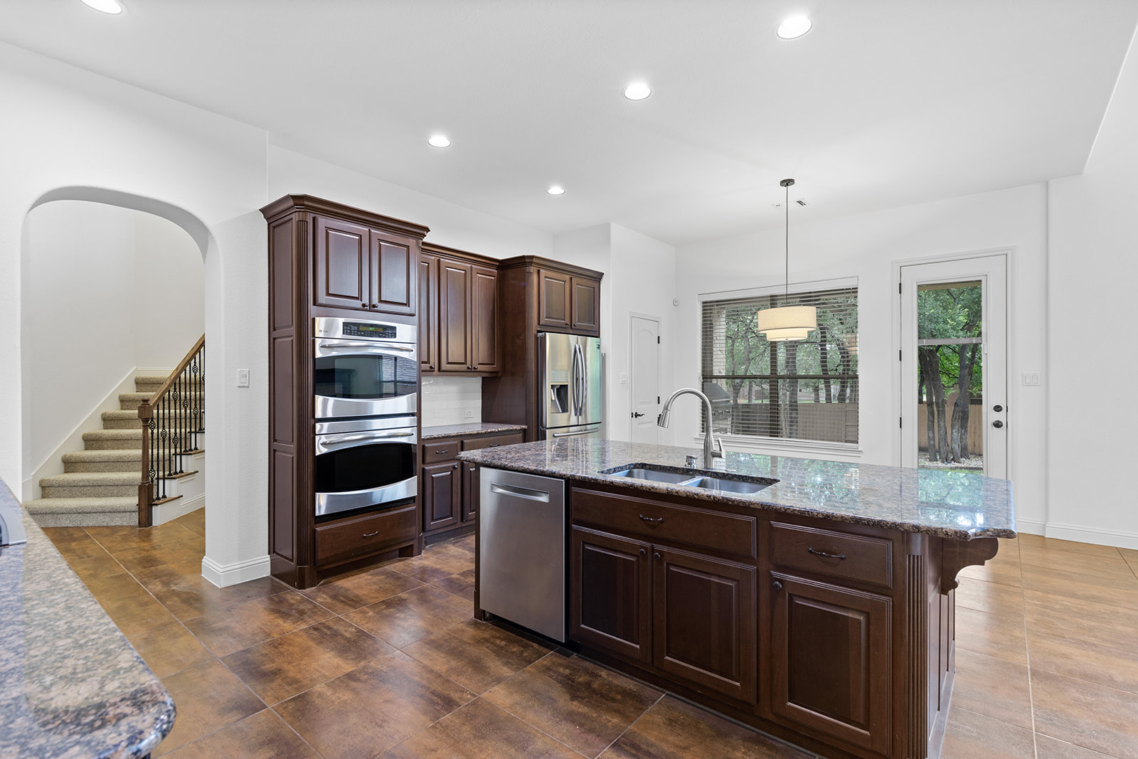 114 North Saddle Ridge Drive Cedar Park, TX 78613 - Photo 12 of 40 a kitchen with kitchen island granite countertop a stove and a sink
