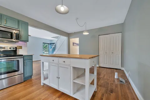 a kitchen with wooden floors and white cabinets